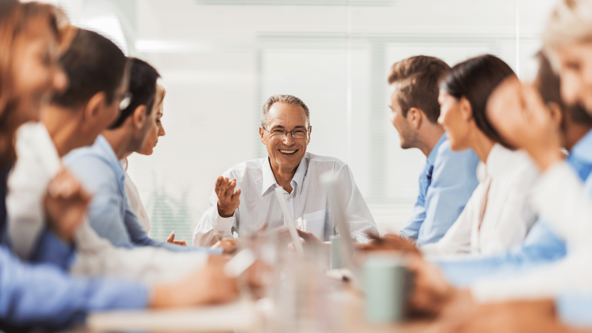 A group of people are sitting around a table having a meeting.