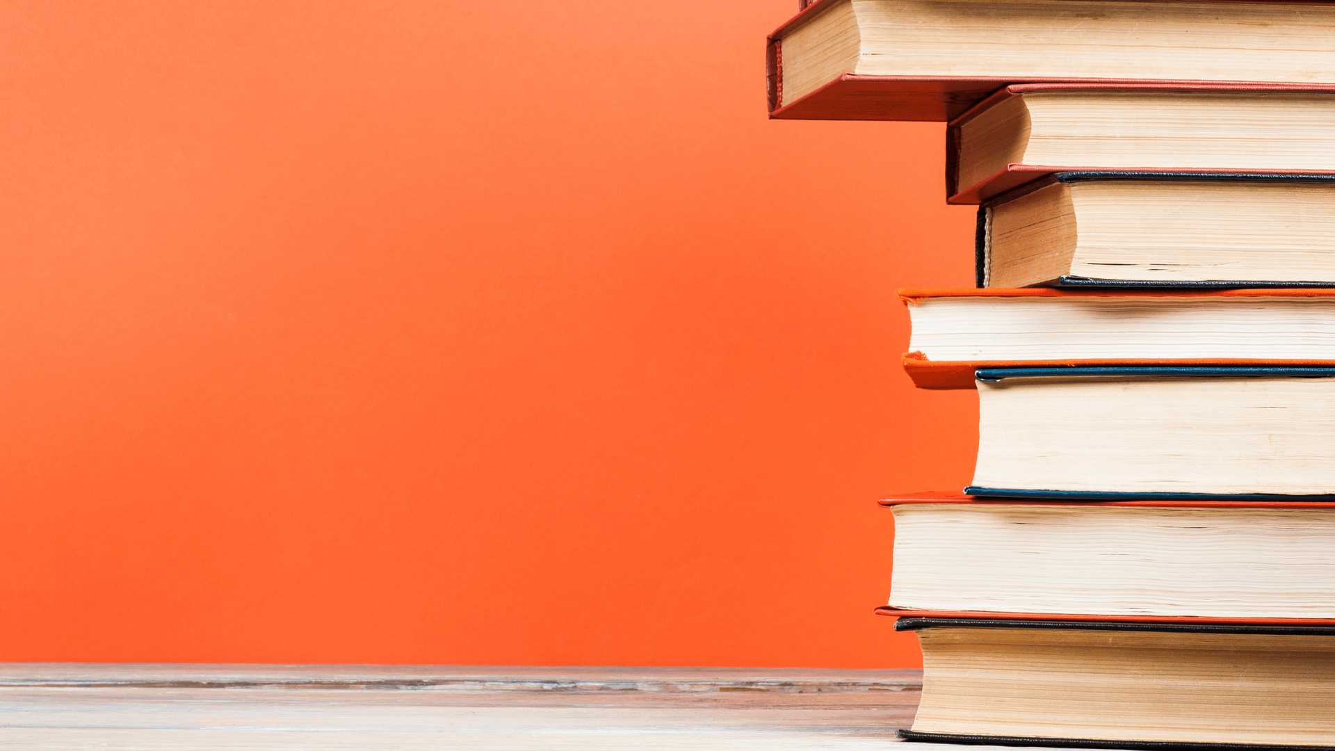 A stack of books sitting on top of each other on a wooden table.