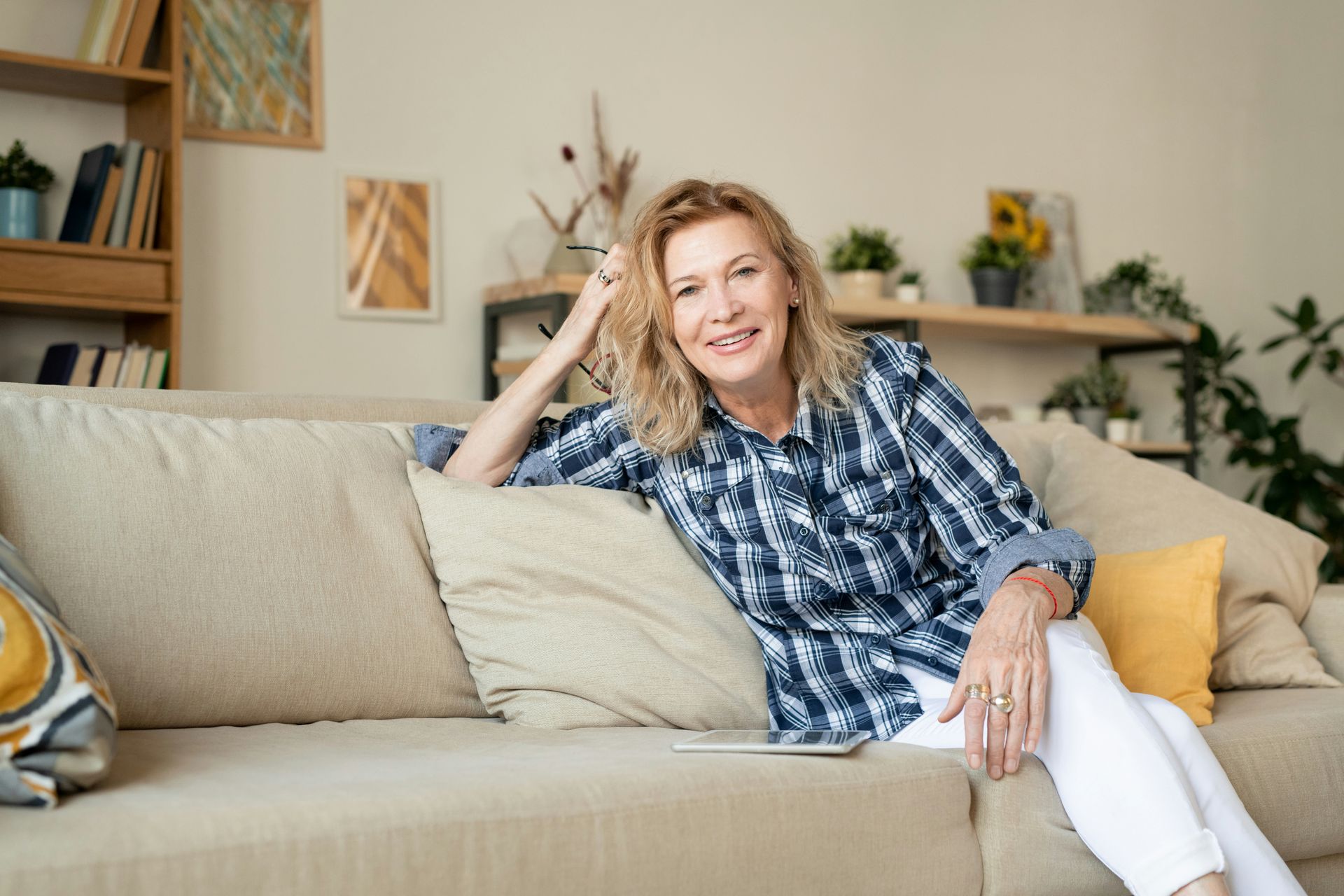 A woman is sitting on a couch in a living room.