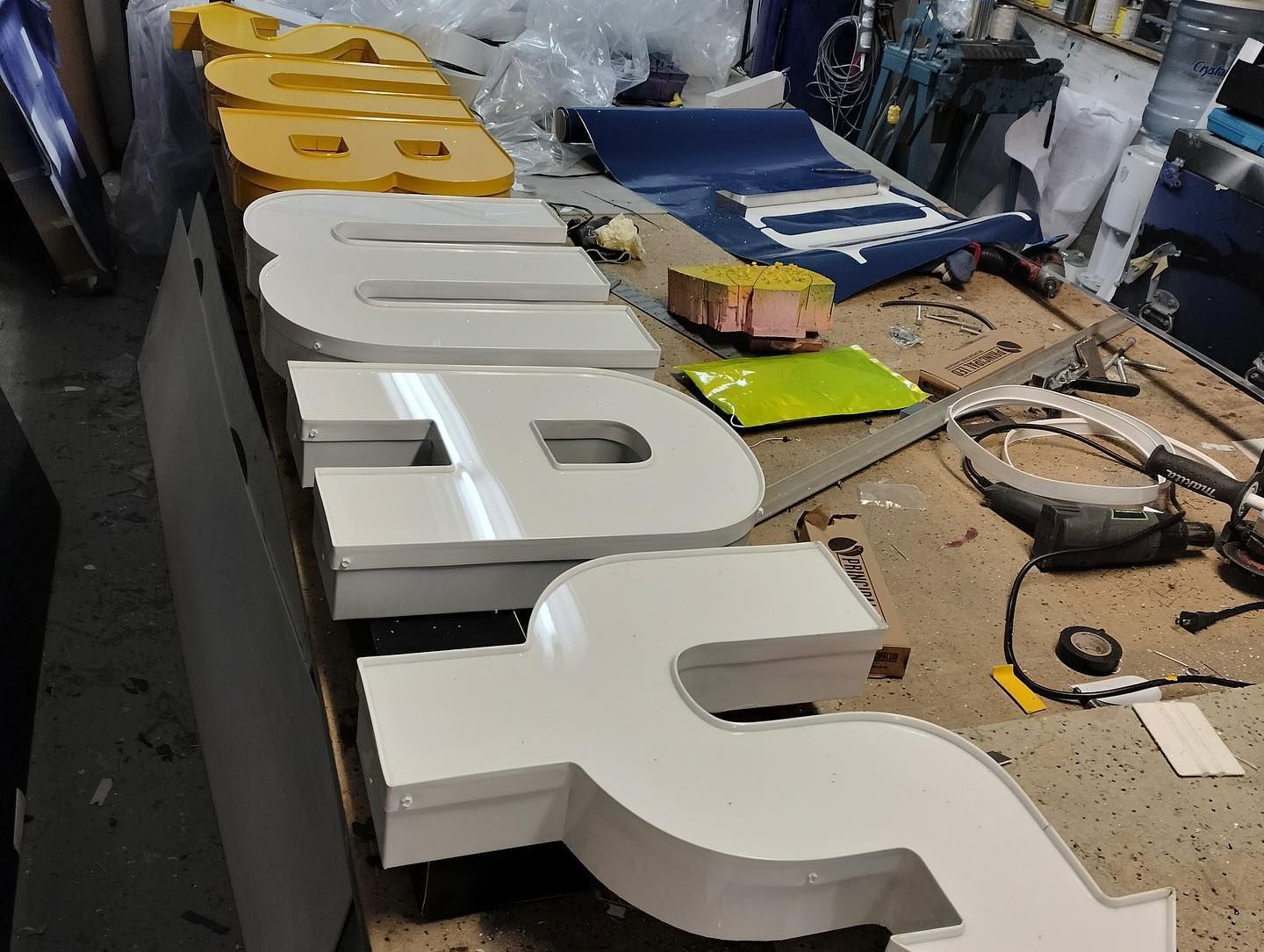 a row of letters sitting on top of a wooden table  for a subway channel letter sign