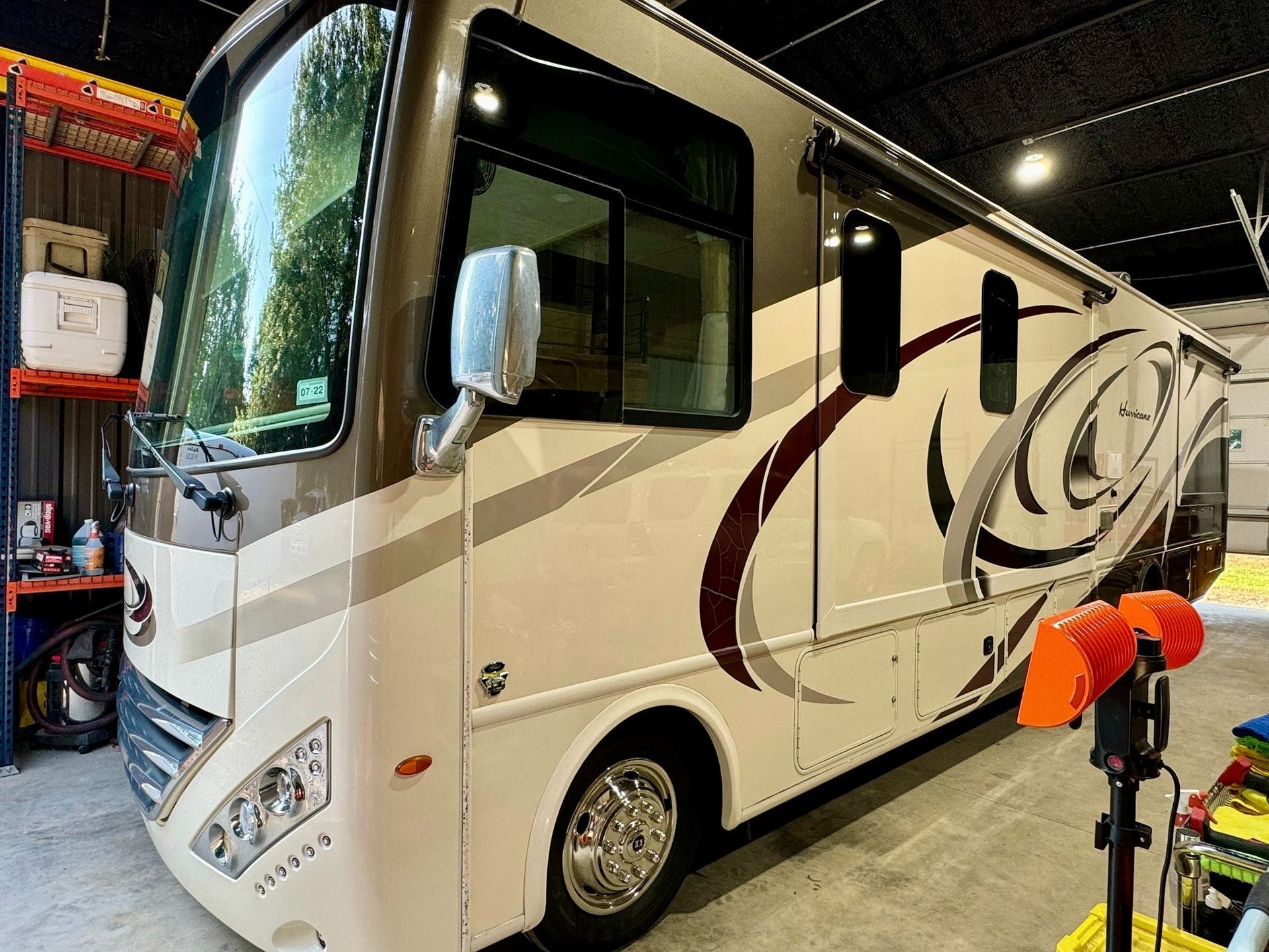 A large white rv is parked in a garage.