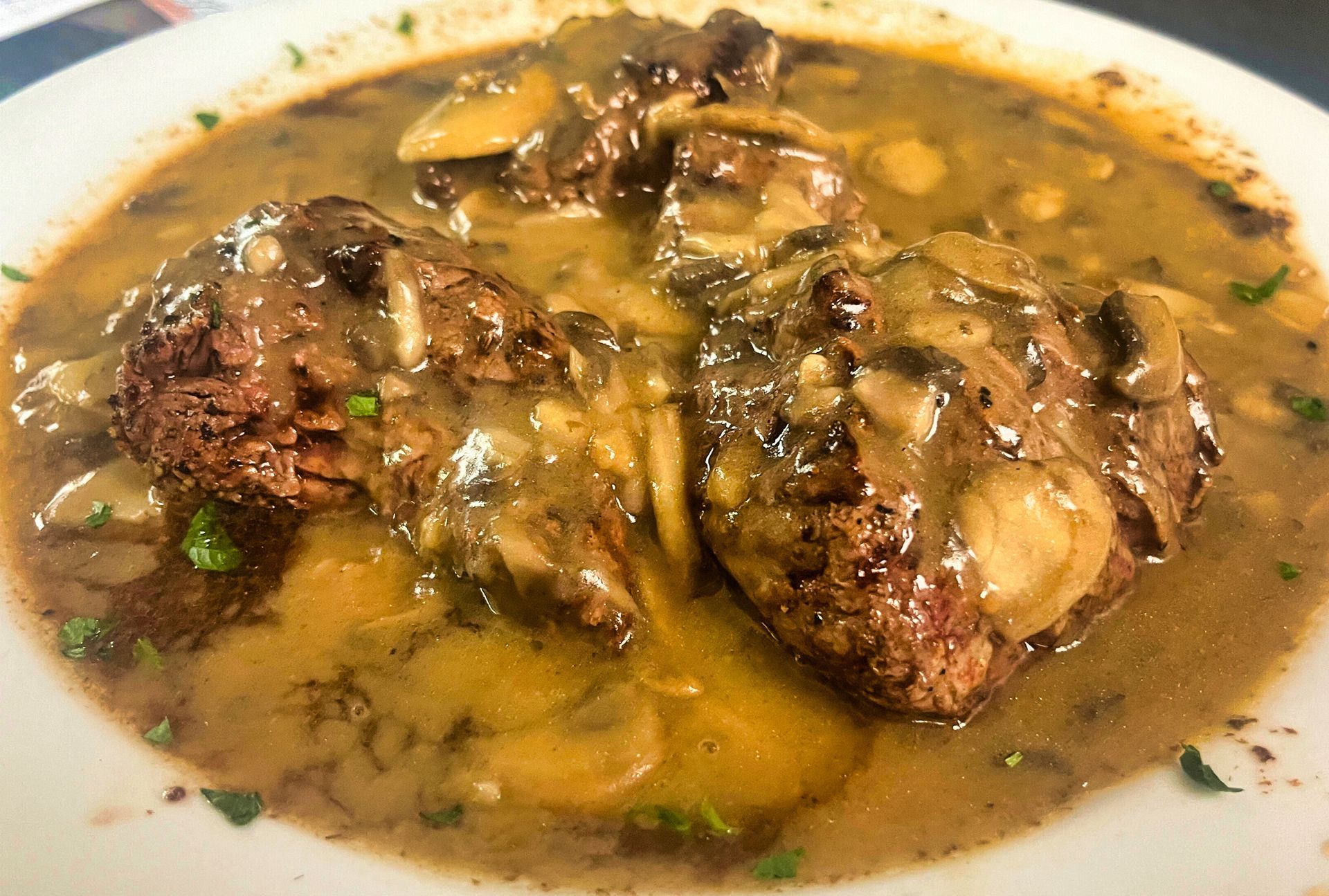 Beef tenderloin medallions with sauce and garnish at Dockers