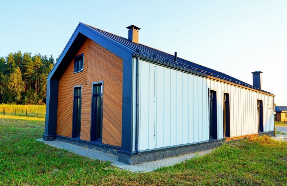 Modern house with brown wood and white siding, black trim, and a grassy yard.