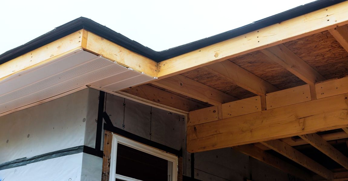 A house under construction with a wooden roof and a window.