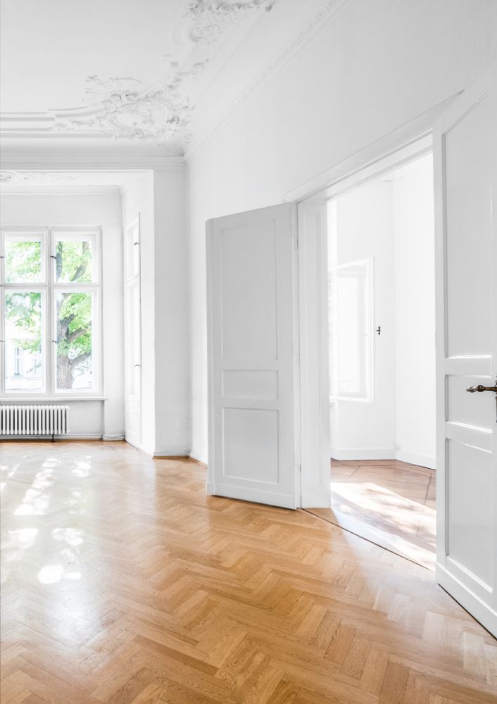 An empty room with a wooden floor and white walls.