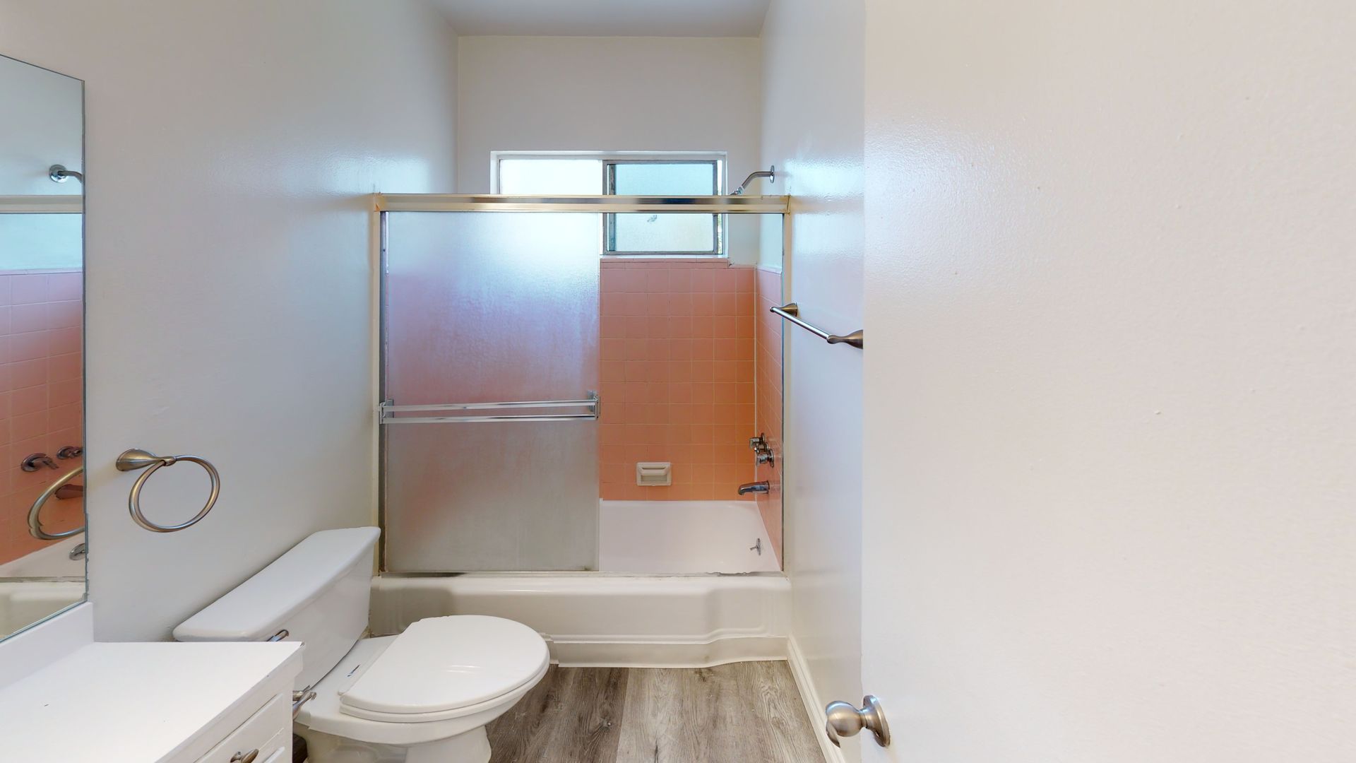 Bathroom with toilet, tub/shower, and vanity, in neutral colors.