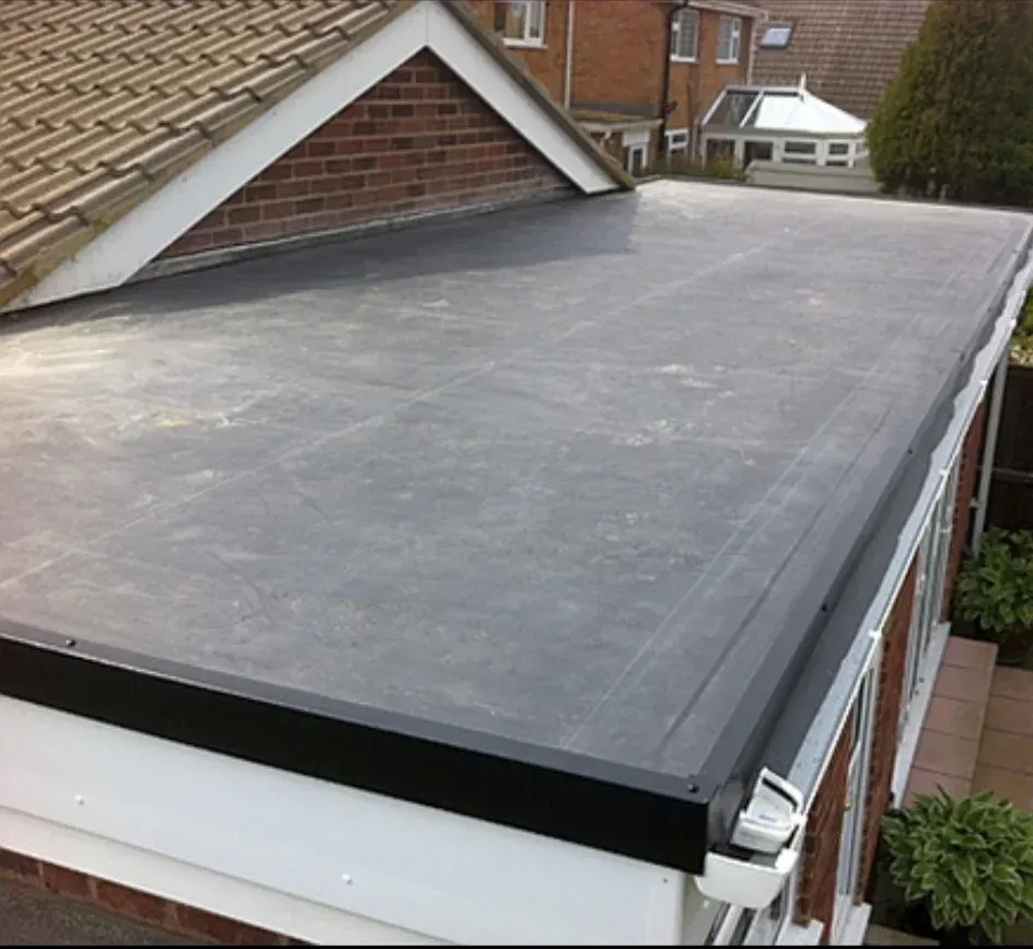 Flat black roofing membrane on a house roof, viewed from above.