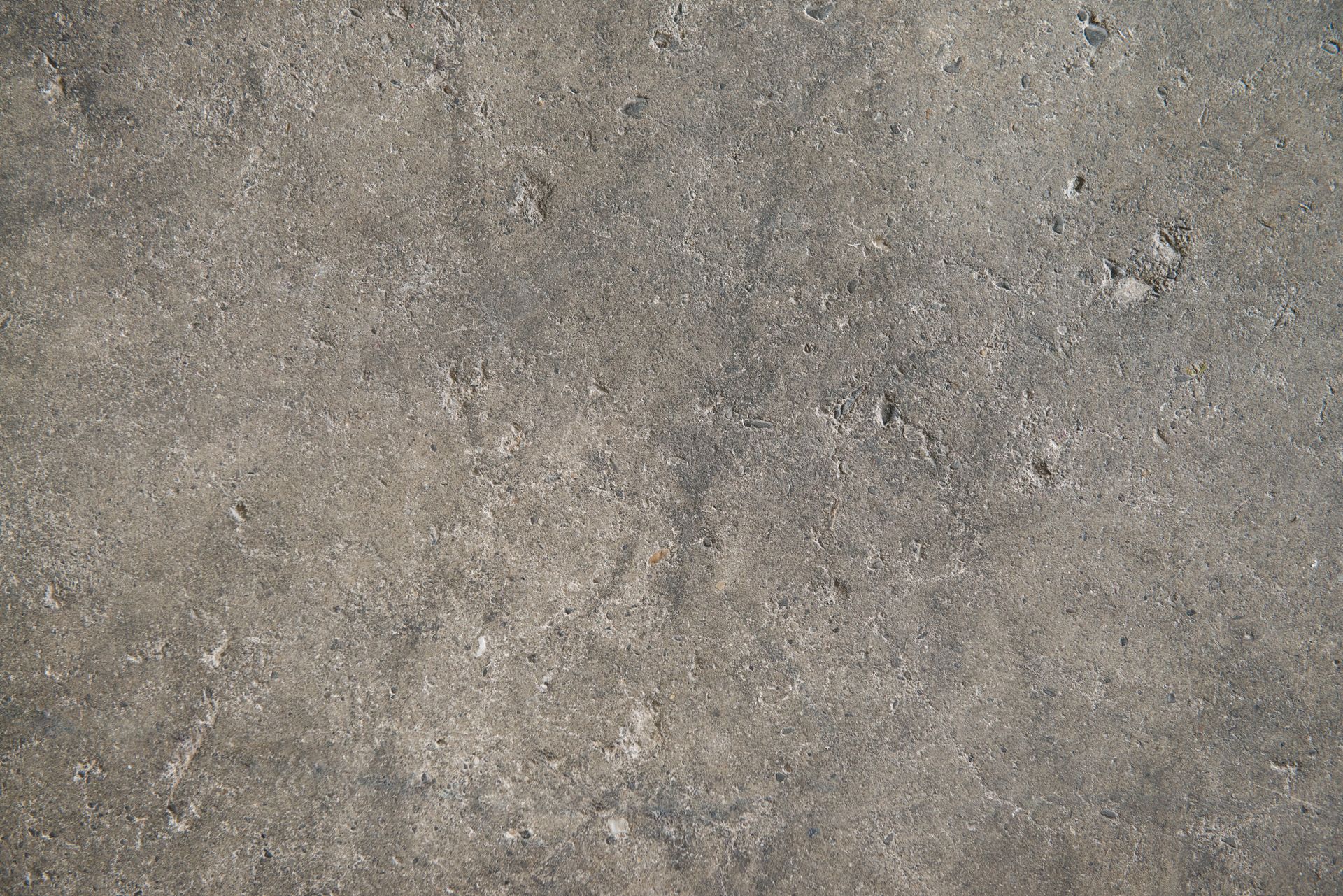 Gray concrete surface with slight texture and small imperfections.