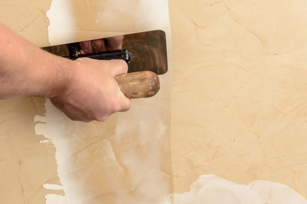 A Person Is Plastering A Wall With A Trowel — Donnelly Painting In Wollongbar, NSW