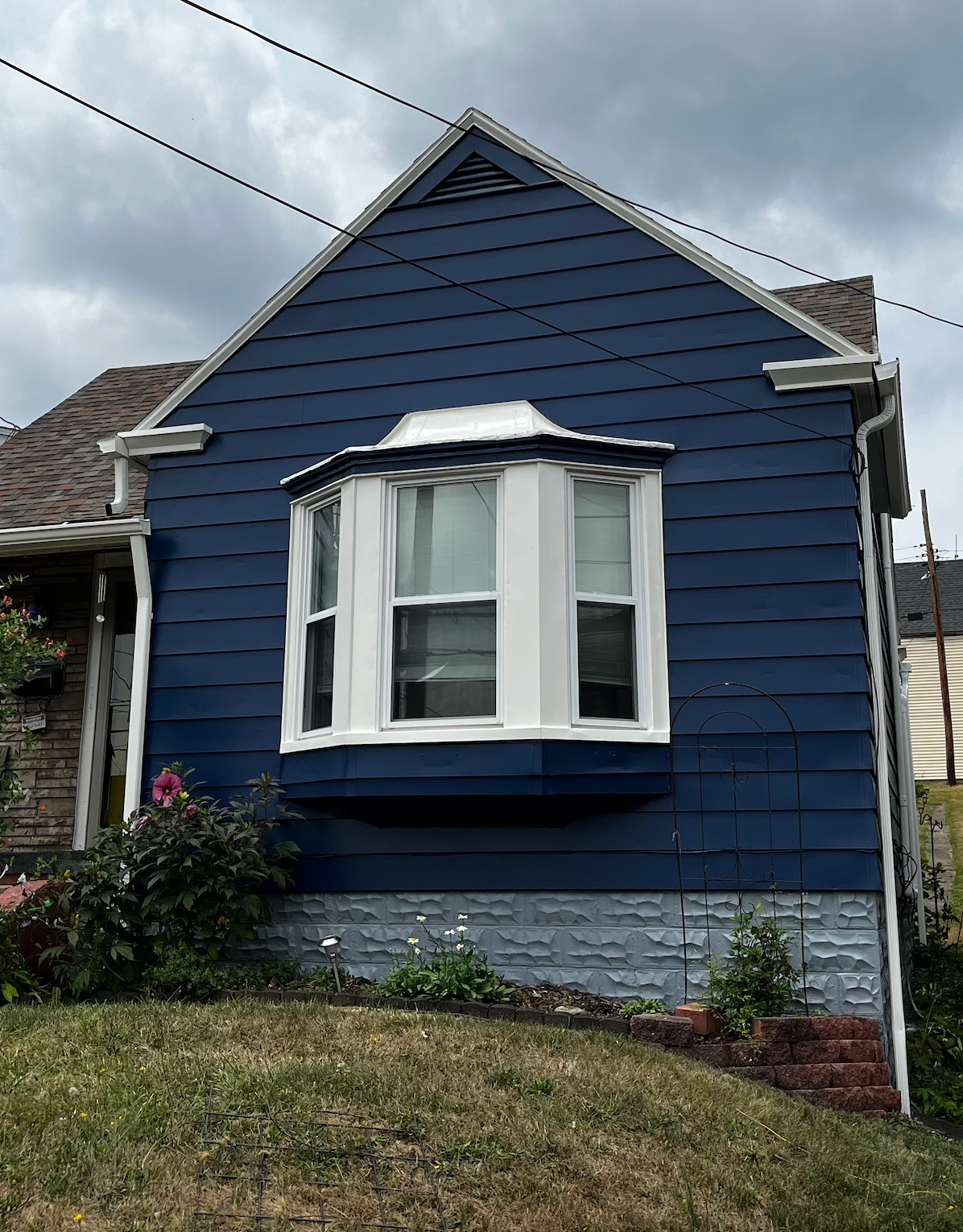 A blue house with a white window and a bay window