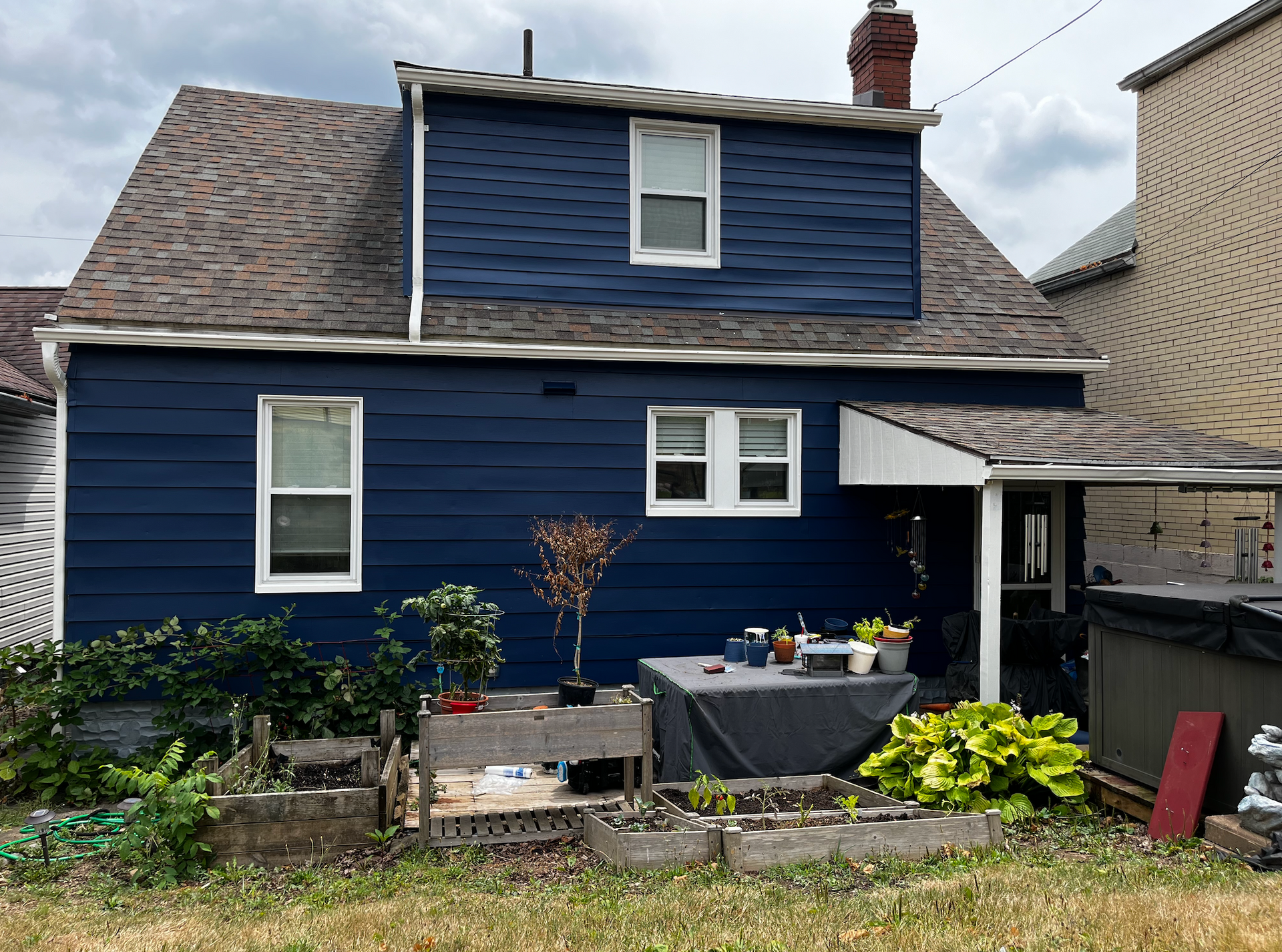 A blue house with a roof and a lot of windows