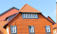 a large house with a tiled roof and a lot of windows .