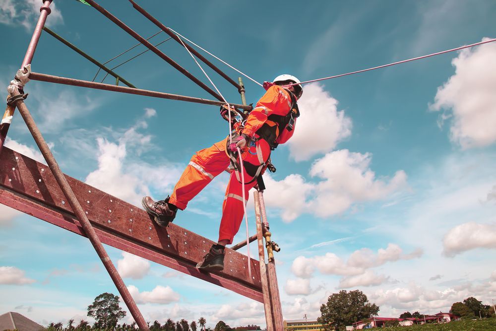 A Worker in a Bright Orange Jumpsuit and Safety Harness  — Air & Lift Gear in Buderim, QLD
