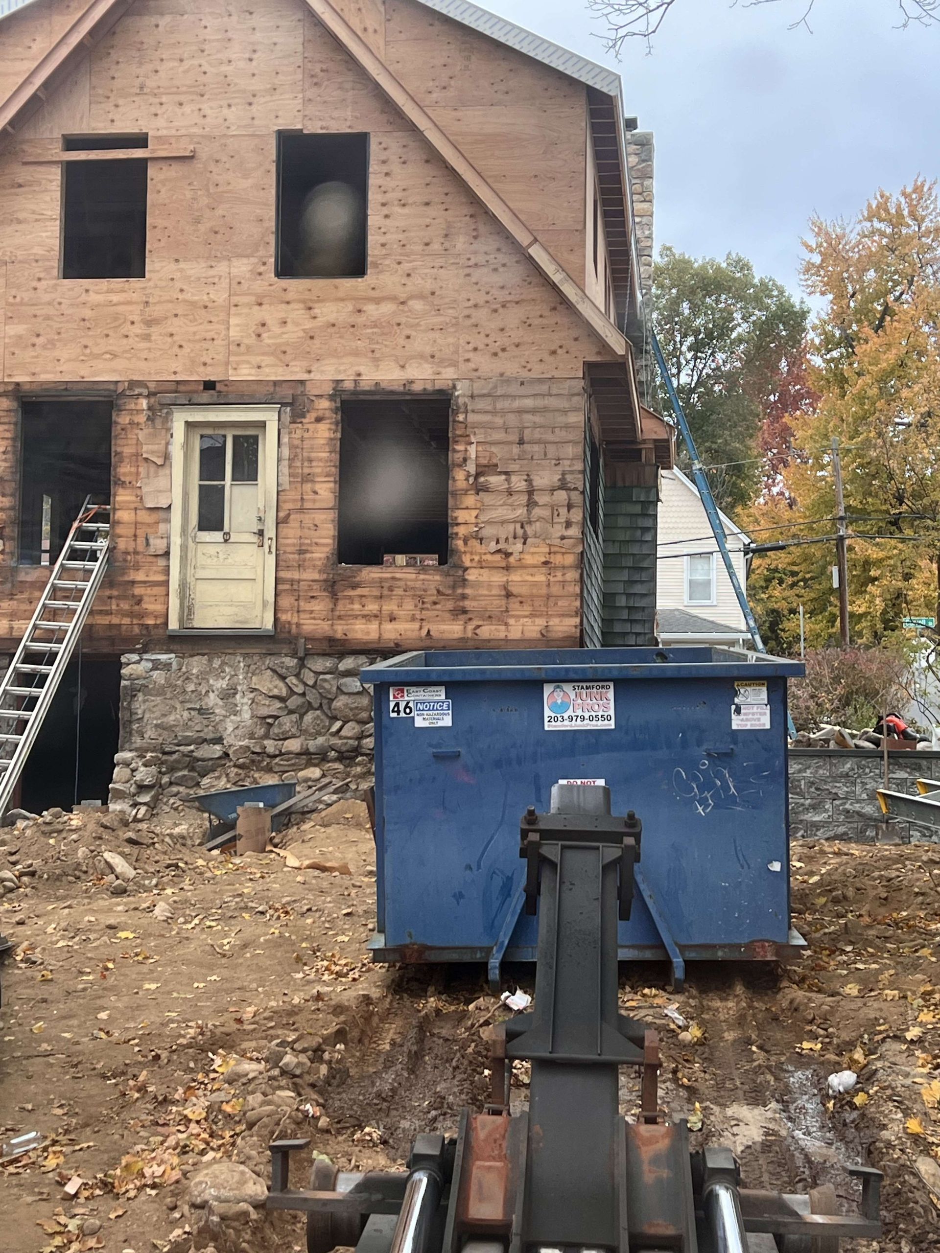 House on Carroll Street in Stamford, CT under renovation, partial wood siding and brick facade.