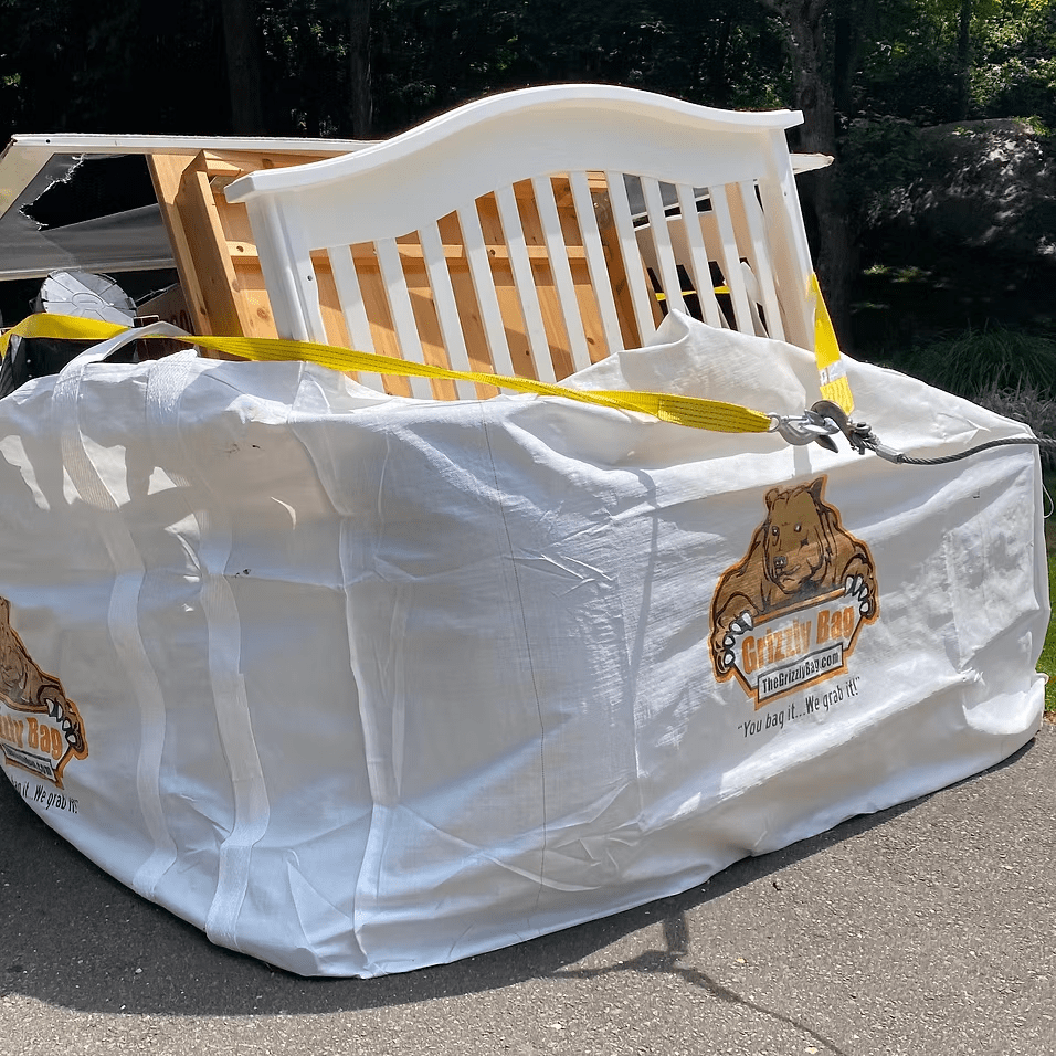 A white bag filled with a crib and other items