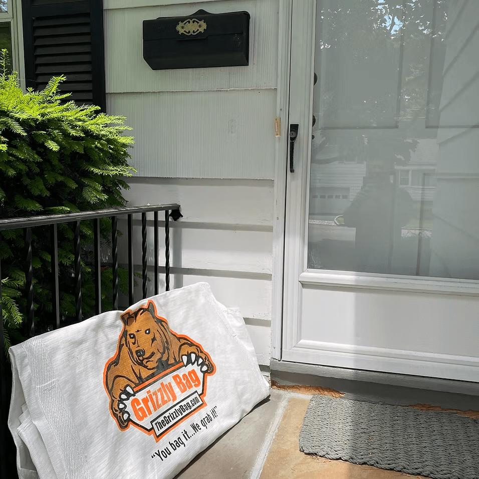 A grizzly bag towel sits on the porch of a house