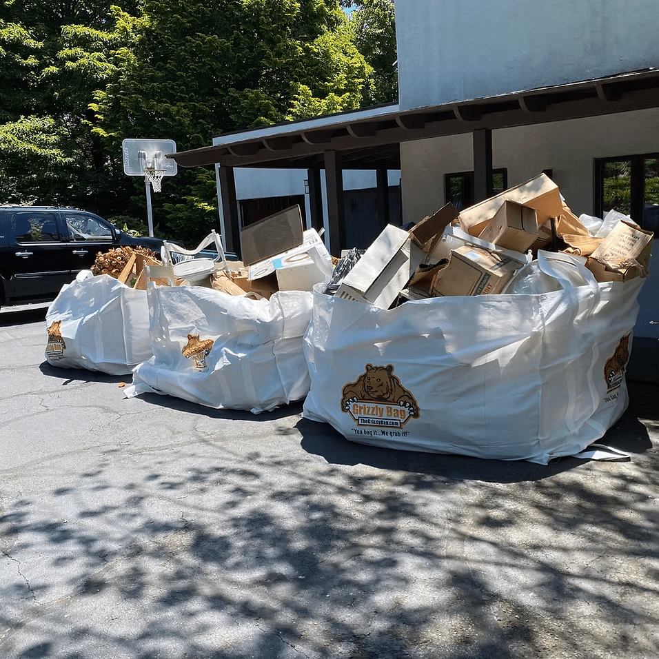 A pile of garbage bags in front of a building