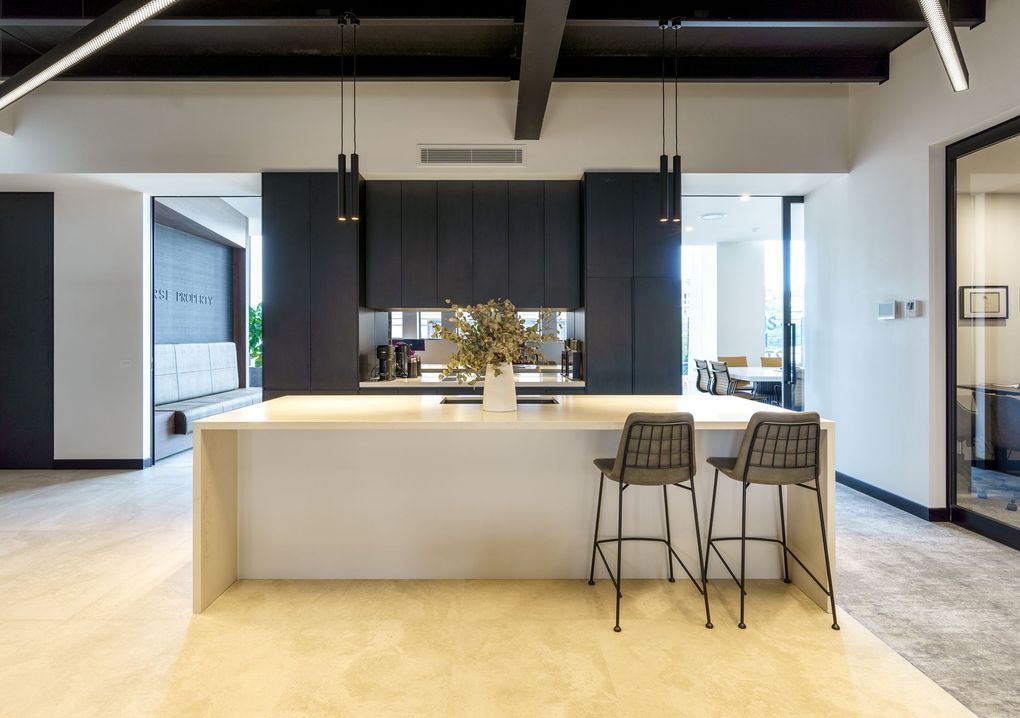 Modern kitchen with large island, dark cabinets, bar stools, and bright open floor plan