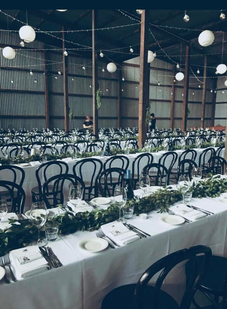 A Long Table With Plates, Utensils, and Chairs Set Up for a Wedding Reception — Hello Poppy Lane Florist In Wodonga, VIC
