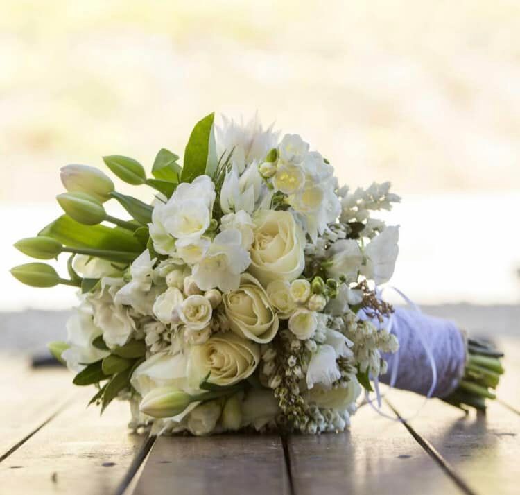 A Bouquet of White Flowers is Sitting on a Wooden Table — Hello Poppy Lane Florist In Wodonga, VIC