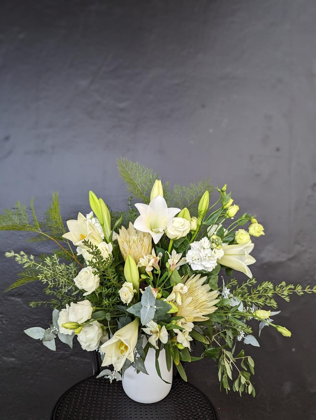 A Vase Filled With White Flowers is Sitting on a Table — Hello Poppy Lane Florist In Wodonga, VIC
