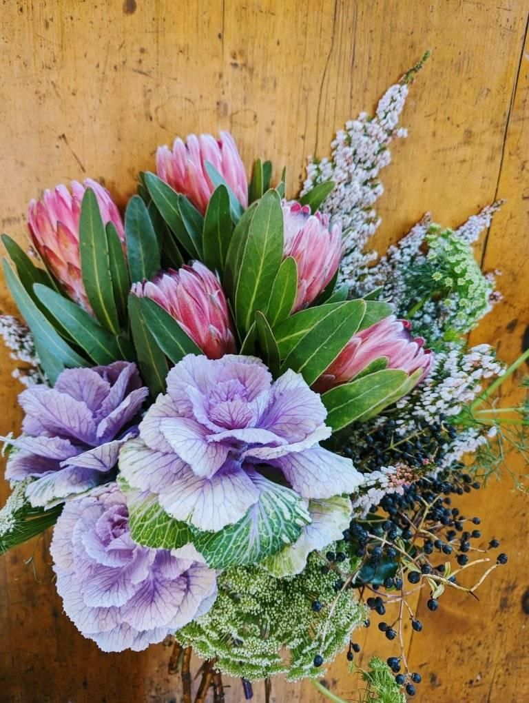 A Bouquet of Flowers is Sitting on a Wooden Table — Hello Poppy Lane Florist In Wodonga, VIC