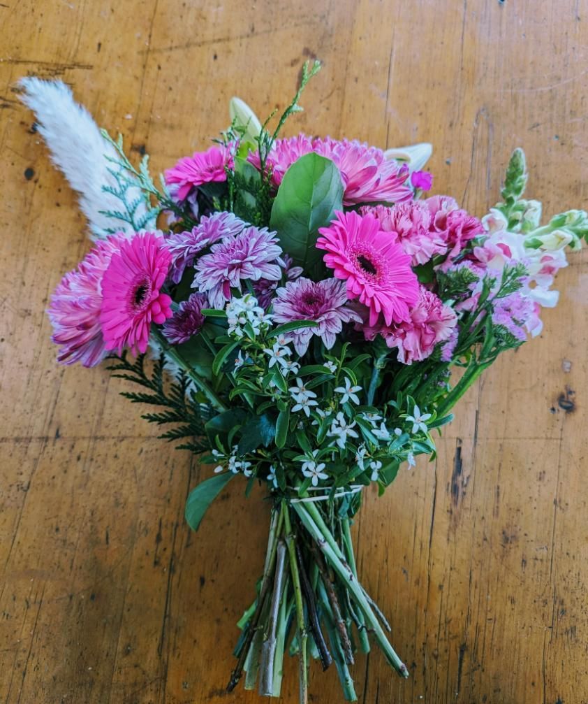 A Bouquet of Pink and Purple Flowers on a Wooden Table — Hello Poppy Lane Florist In Wodonga, VIC