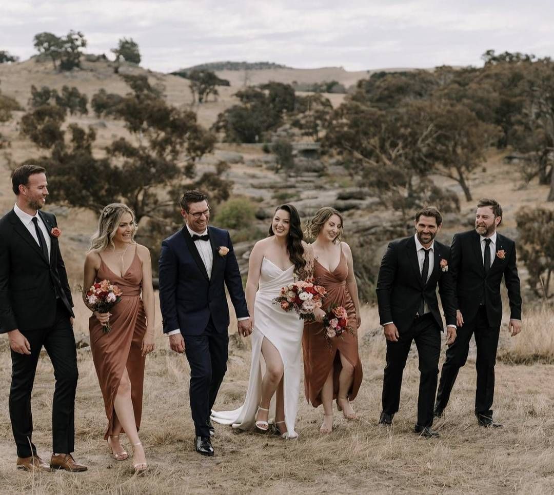 A Bride and Groom Are Walking With Their Wedding Party in a Field — Hello Poppy Lane Florist in Rutherglen, NSW