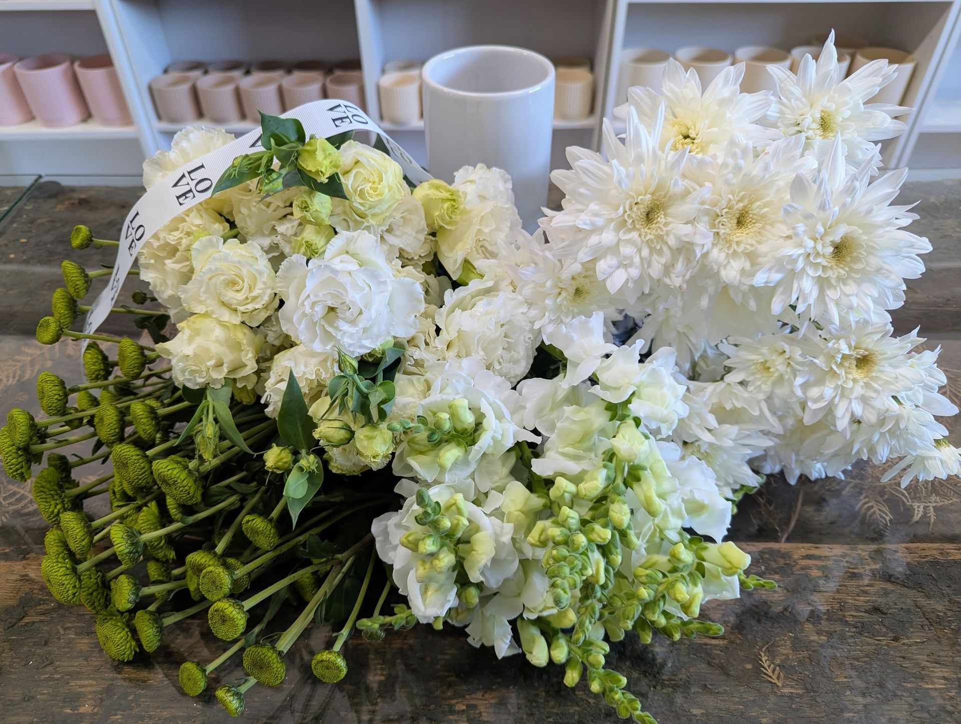 A Bunch of White Flowers Are Sitting on a Table Next to a Vase — Hello Poppy Lane Florist In Albury, VIC