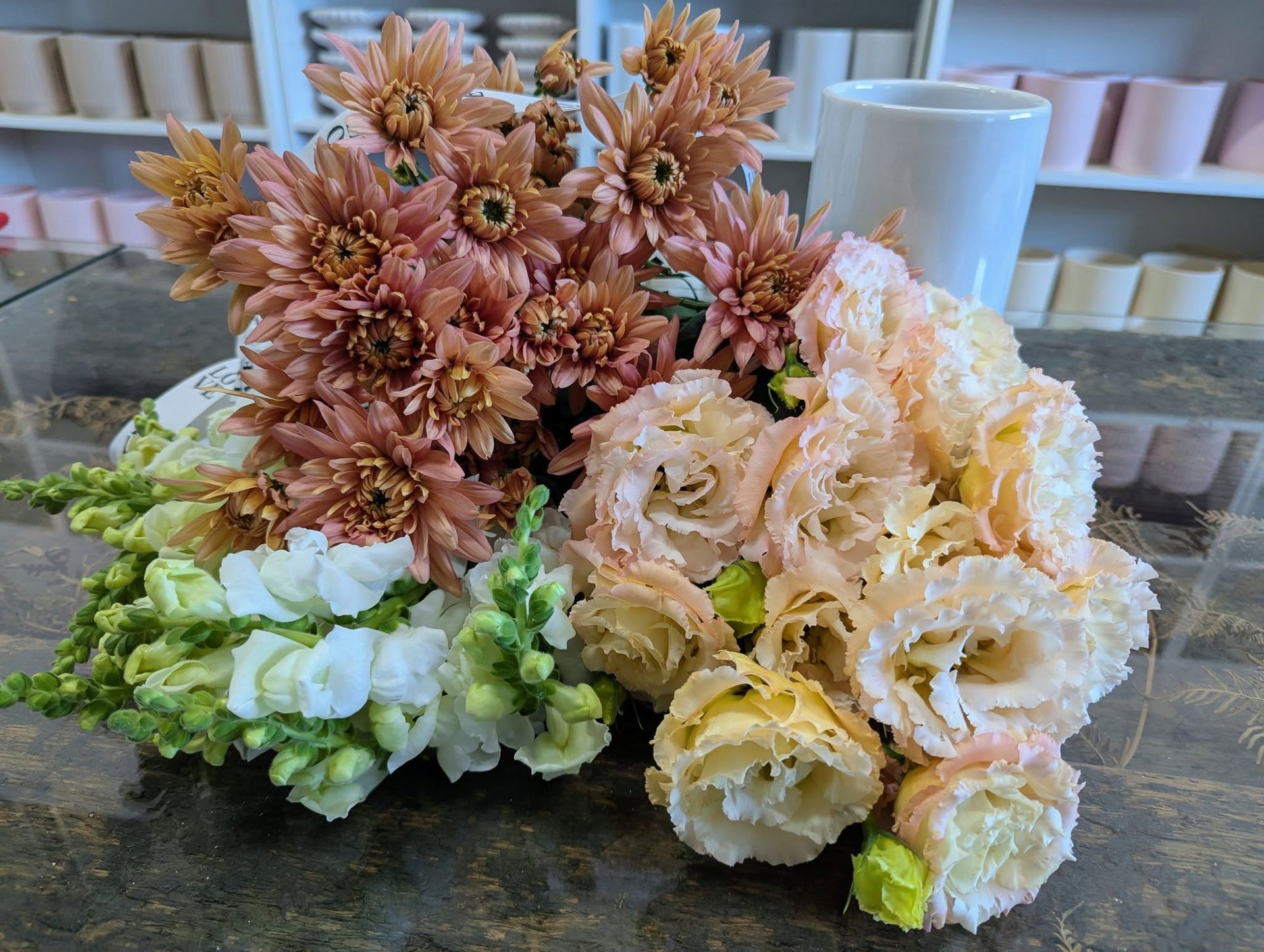 A Bunch of Flowers Are Sitting on a Table Next to a Cup — Hello Poppy Lane Florist In Albury, VIC