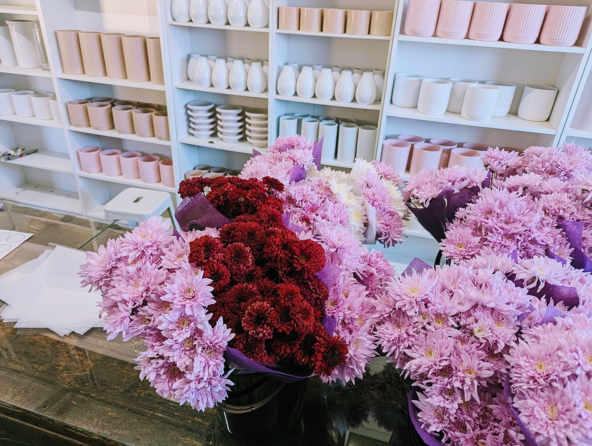 A Bunch of Pink and Red Flowers Are Sitting on a Table in a Store — Hello Poppy Lane Florist In Albury, VIC