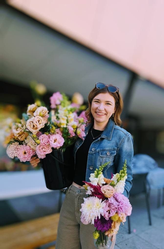 A Woman in a Denim Jacket is Holding a Large Bouquet of Flowers — Hello Poppy Lane Florist In Rutherglen, NSW