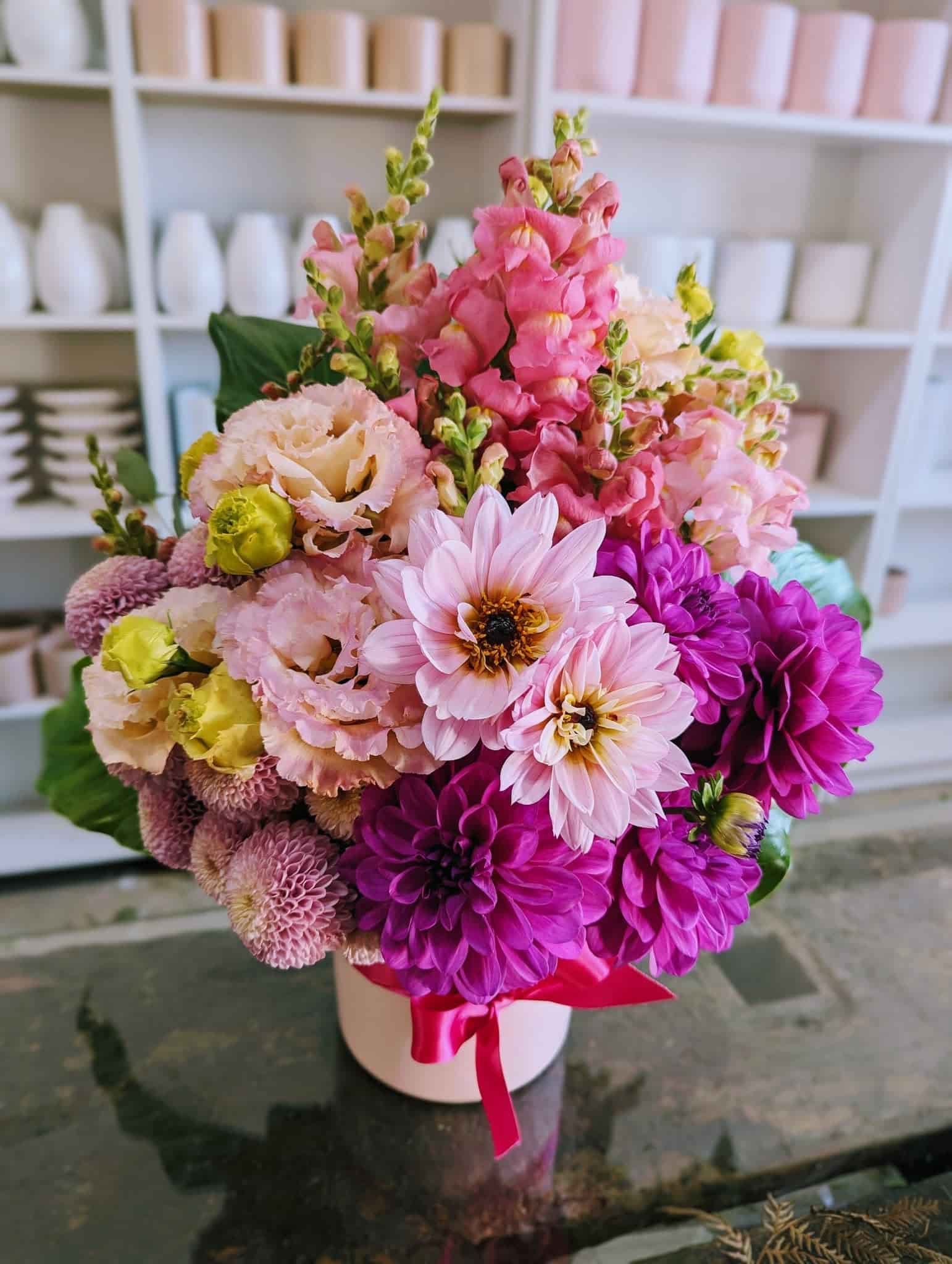 A Vase Filled With Pink and Purple Flowers is Sitting on a Table — Hello Poppy Lane Florist In Rutherglen, NSW