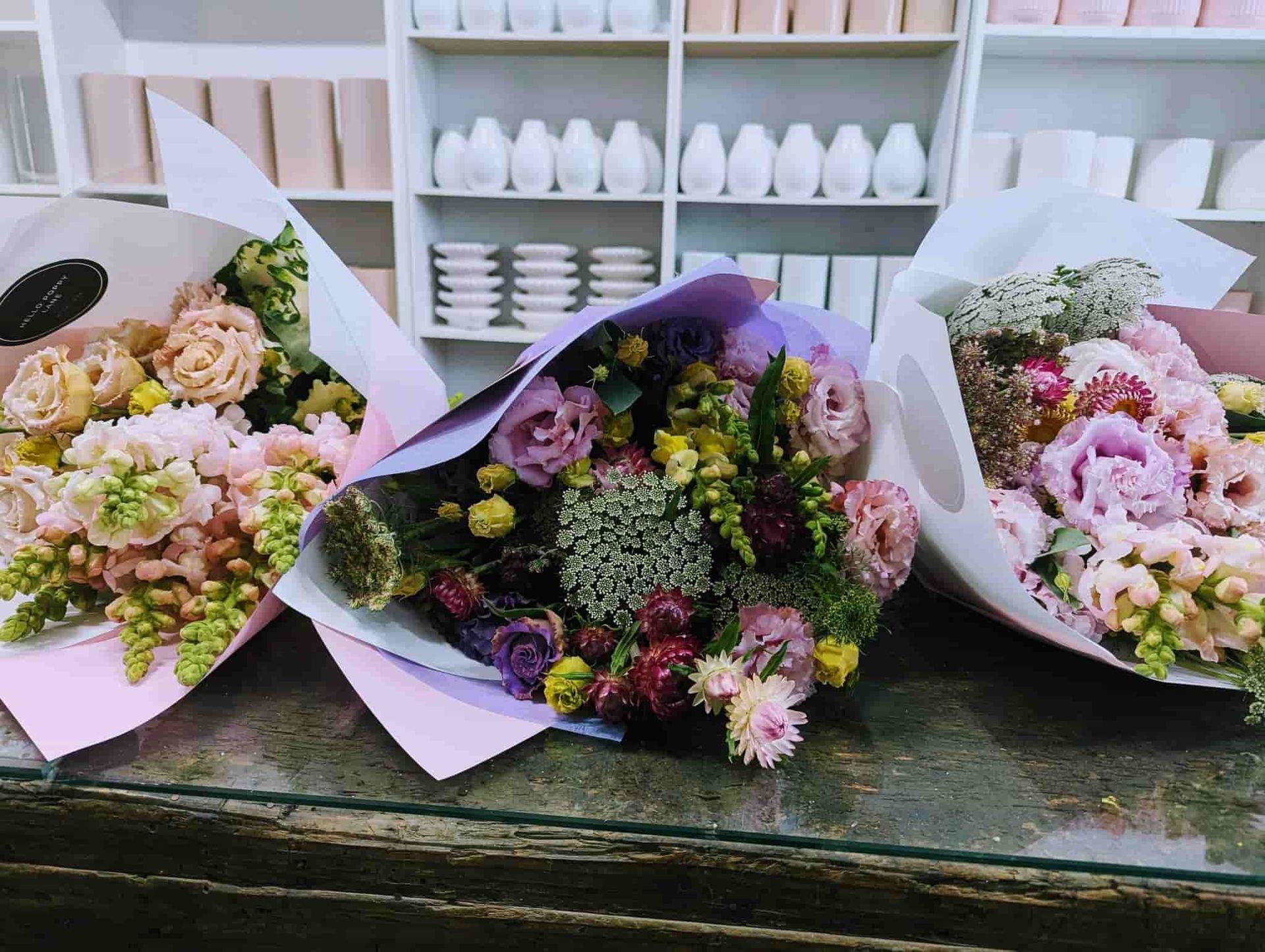 Three Bouquets of Flowers Are Sitting on a Table in a Store — Hello Poppy Lane Florist In Rutherglen, NSW