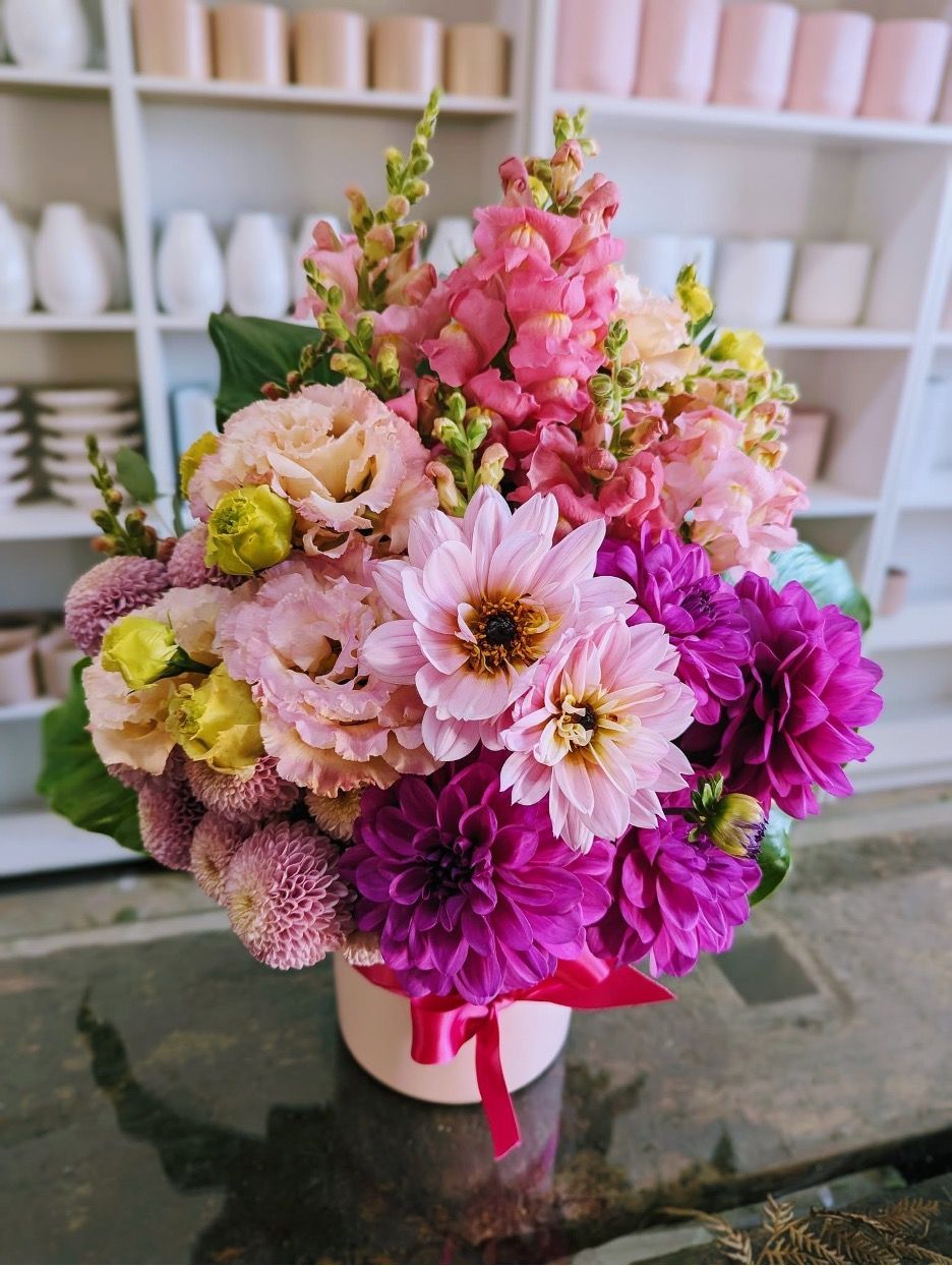 A Vase Filled With Pink and Purple Flowers is on a Table — Hello Poppy Lane Florist in Albury, NSW