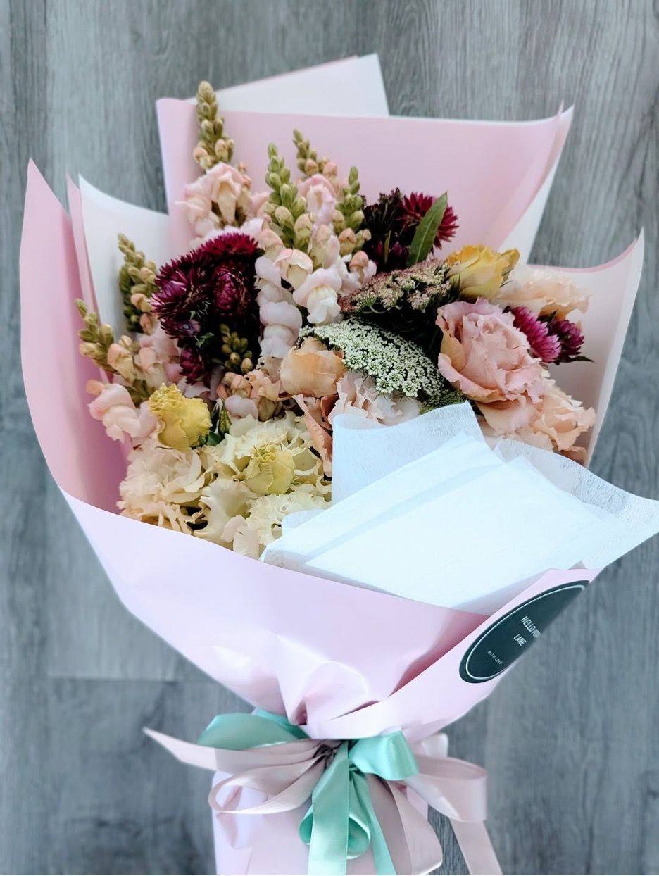 A Bouquet of Flowers Wrapped in Pink Paper With a Green Ribbon — Hello Poppy Lane Florist in Albury, NSW