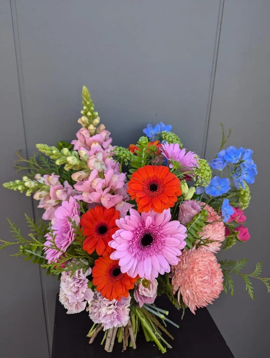 A Bouquet Of Flowers Is Sitting On A Table In Front Of A Wall — Hello Poppy Lane Florist In Ebden, VIC