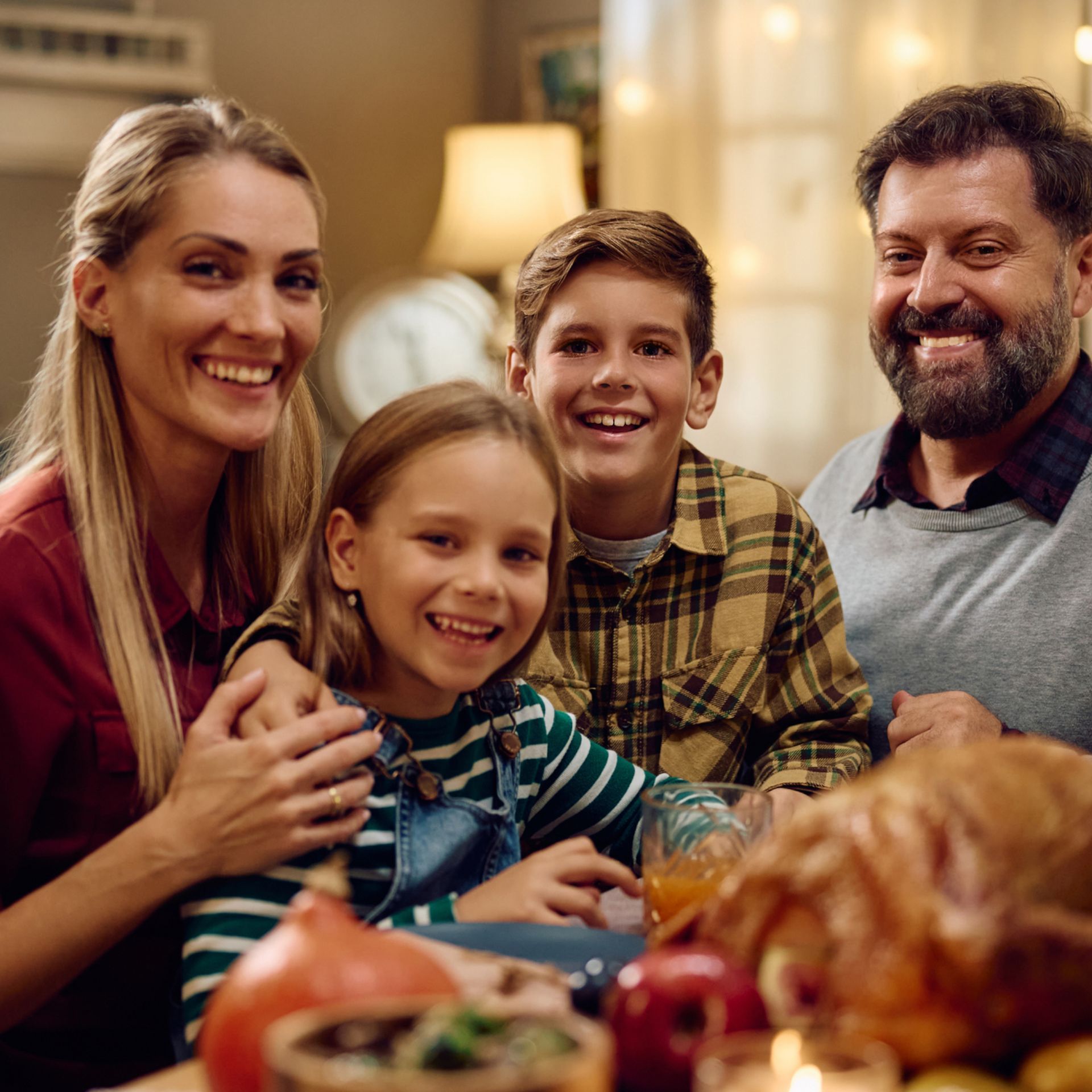 A family is posing for a picture while sitting at a table.