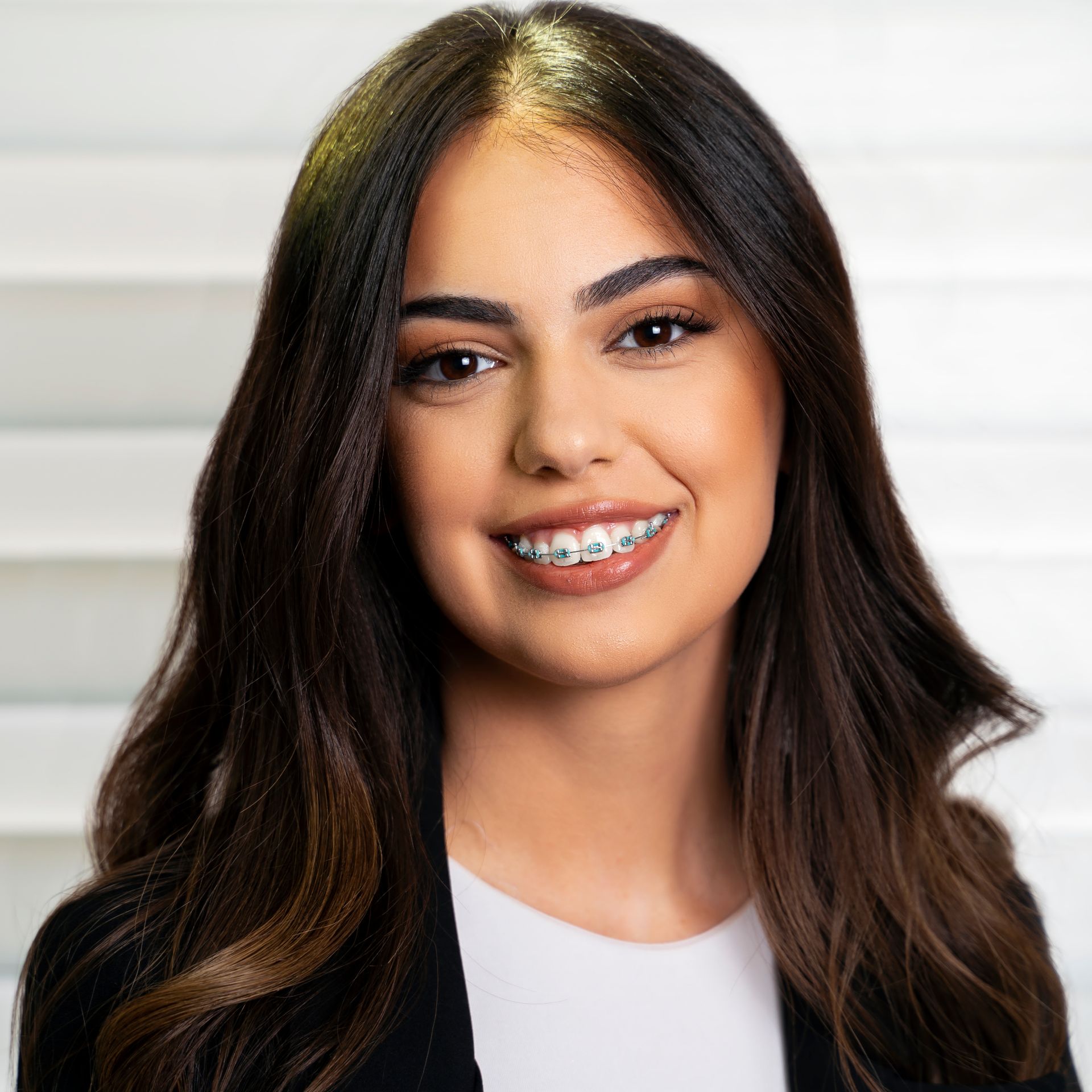 A woman with braces on her teeth is smiling for the camera.