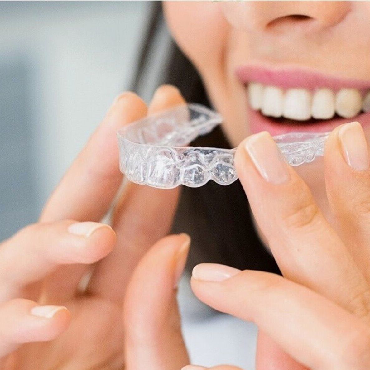 closeup image of a woman putting an aligner in