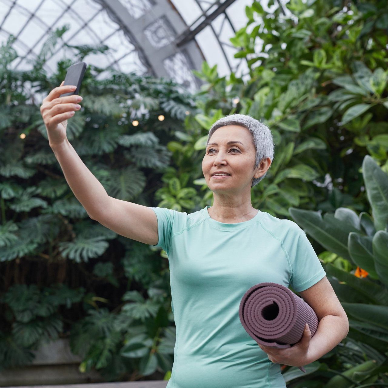 older woman taking a selfie after doing yoga, smiling