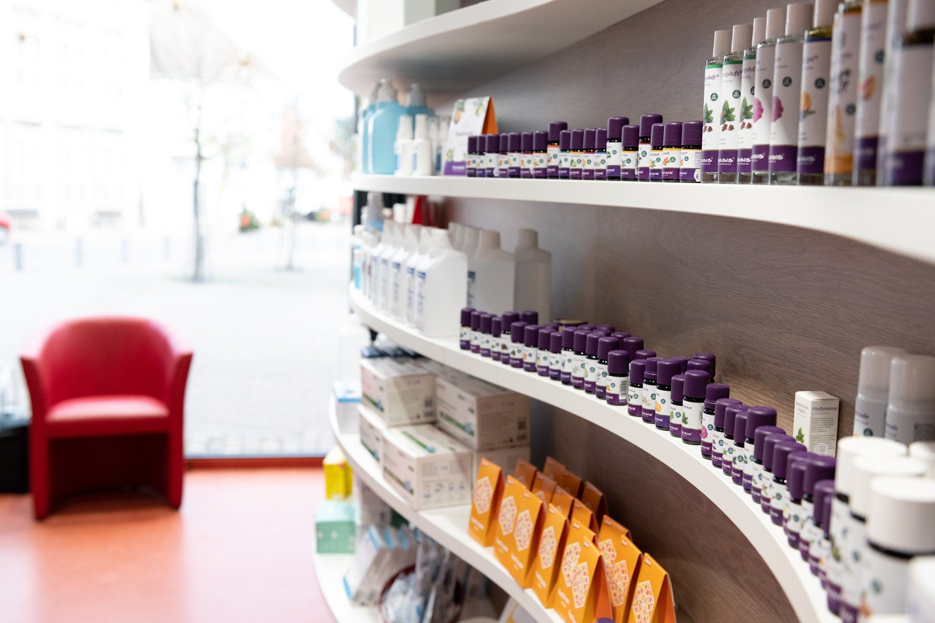 Eine Apotheke mit einem roten Stuhl und Regalen voller Kosmetika.