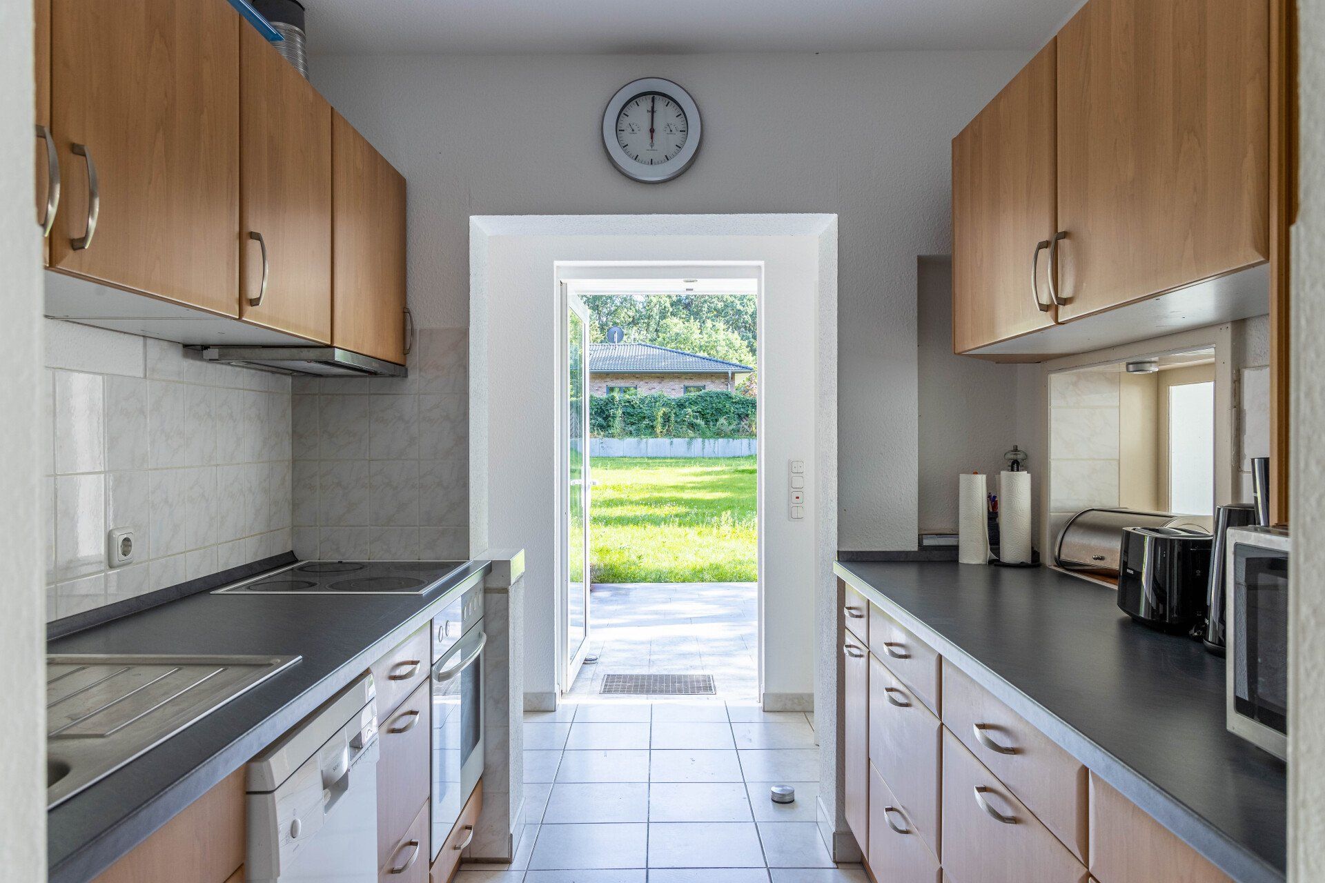 Eine Küche mit Holzschränken und einer Uhr an der Wand