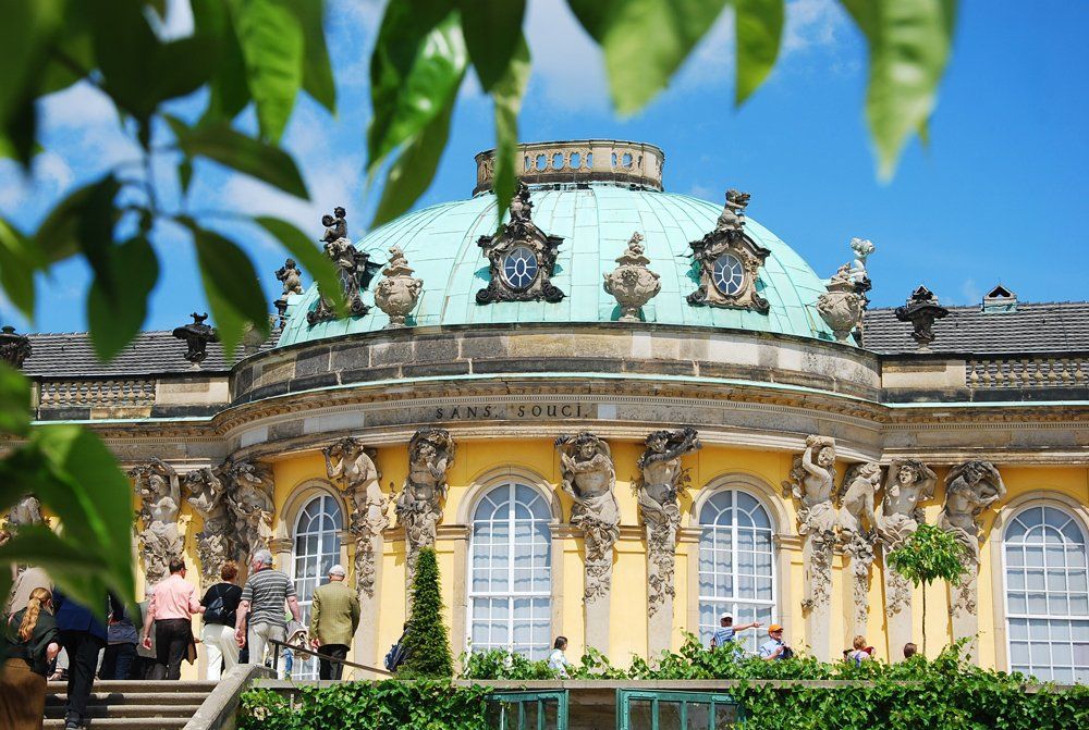 Ein großes gelbes Gebäude mit einer grünen Kuppel oben drauf