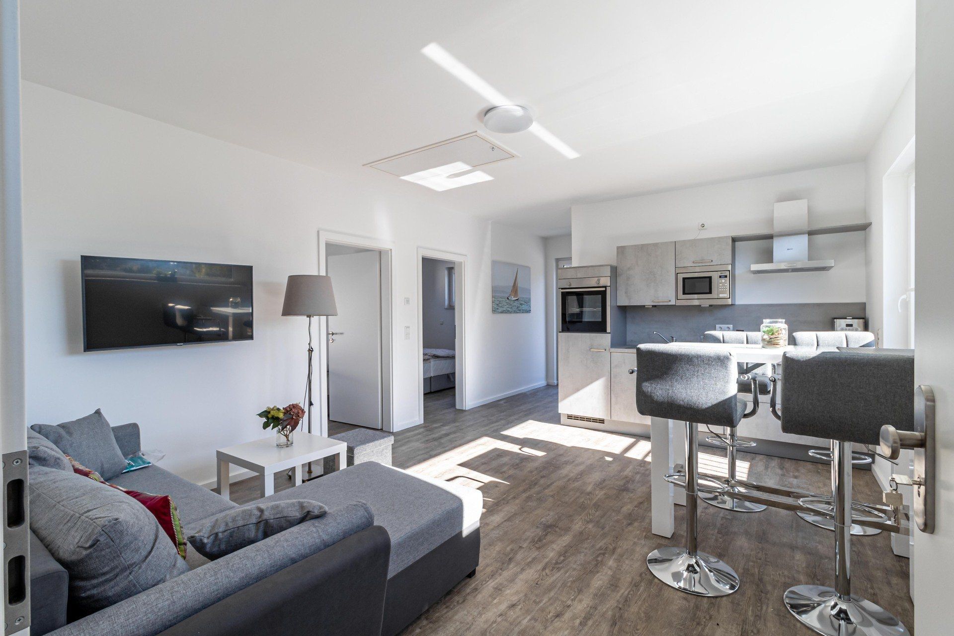 Ein Wohnzimmer mit Couch, Tisch, Stühlen und Fernseher.