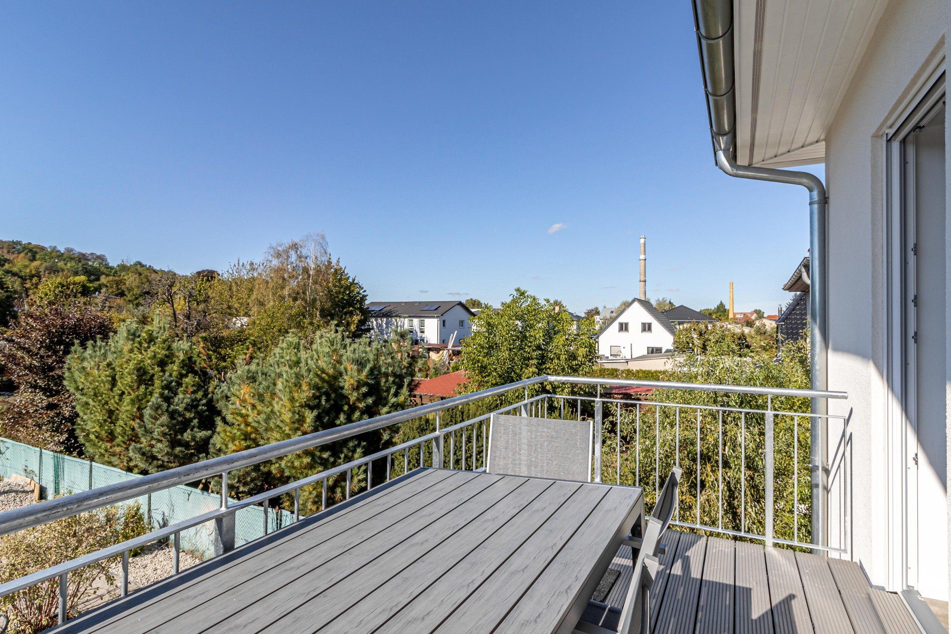 Es gibt einen Balkon mit einem Tisch und Stühlen.