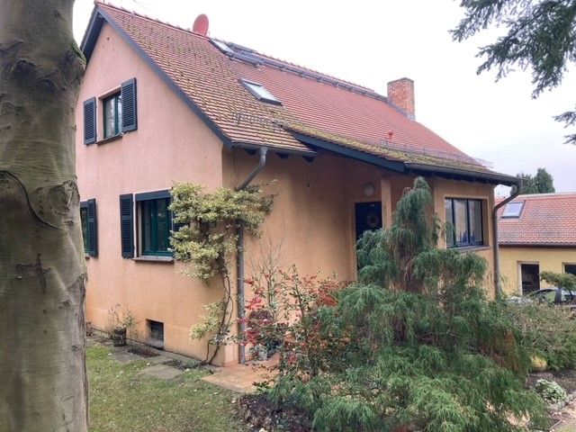 Ein Haus mit einem roten Dach und einem Baum davor