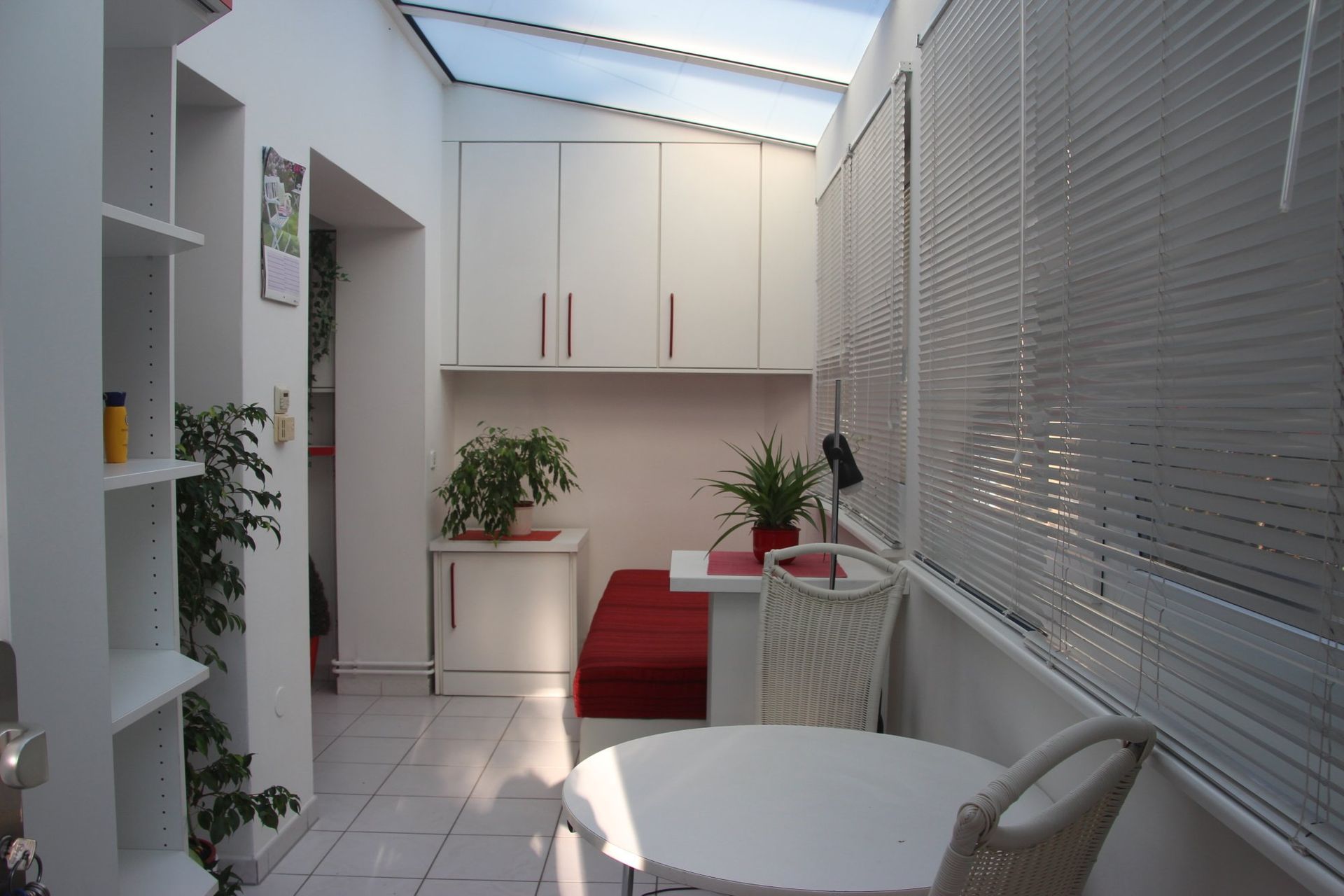 Ein Raum mit Tisch und Stühlen und Jalousien an den Fenstern