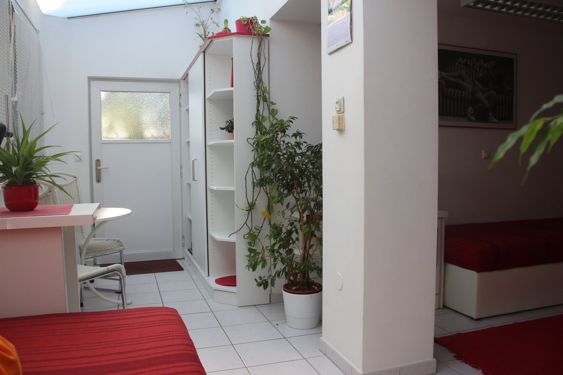 Ein Flur mit einer weißen Tür und einem roten Teppich