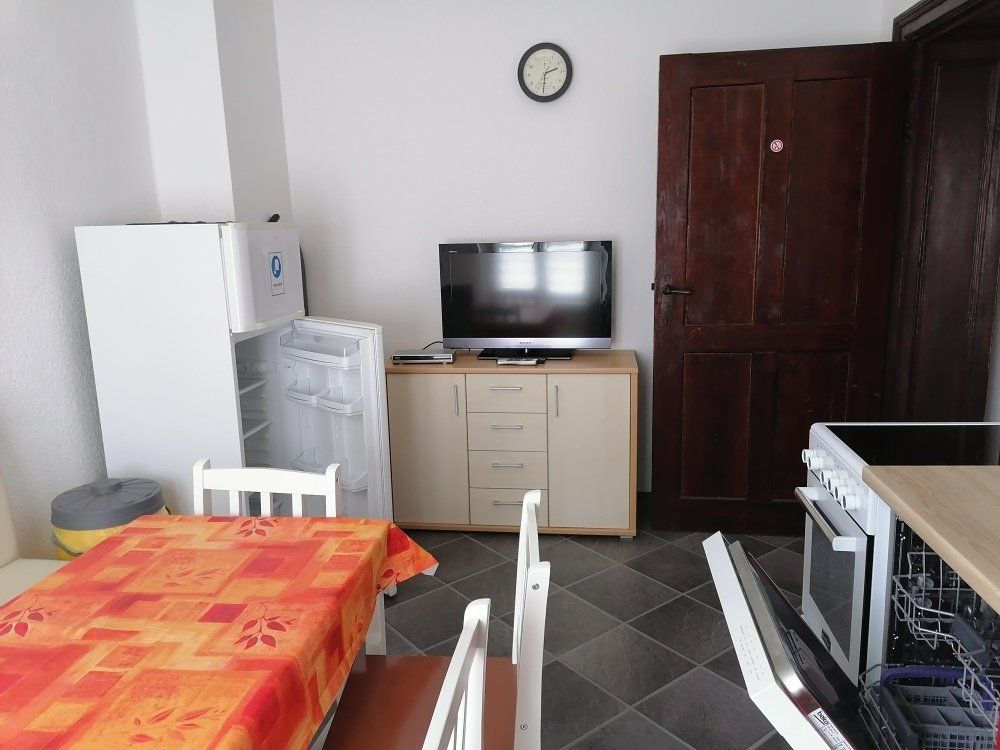 Eine Küche mit Tisch und Stühlen und einem Fernseher